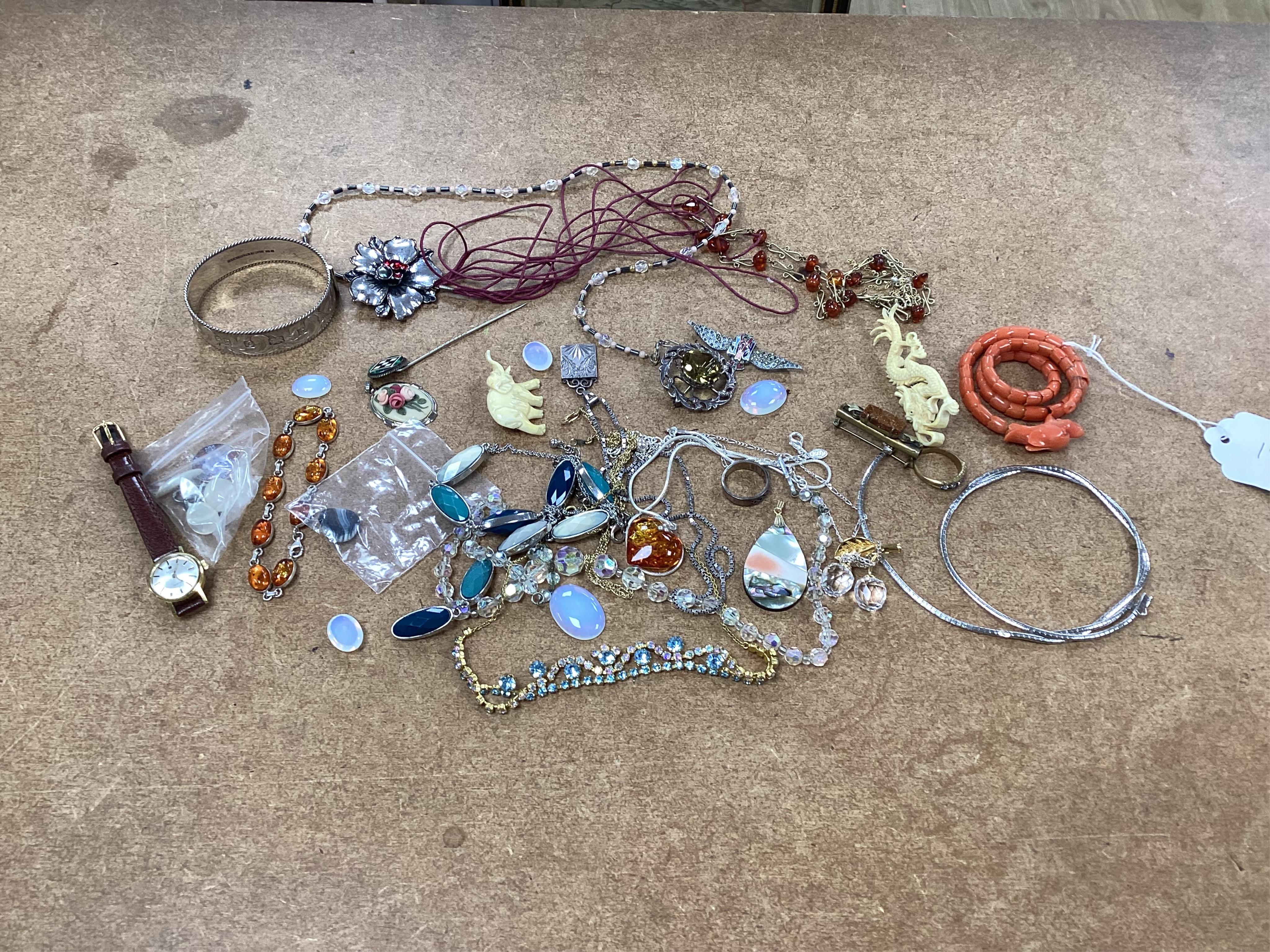 A small quantity of assorted jewellery including a coral set coiled dragon bracelet, a 1970's engraved silver hinged bangle, a Scottish silver and citrine brooch and costume. Condition - poor to fair to good